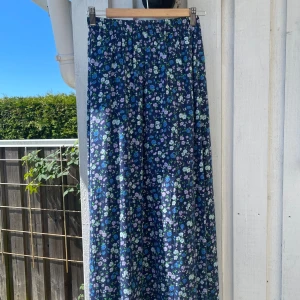 Blommig kjol  - Enormt vacker kjol med blommigt mönster. Den har två slitsar på sidan av benen och är ganska lång! 