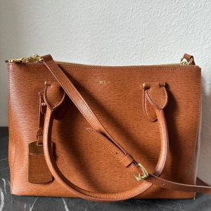 Ralph Lauren väska - Väska från Ralph Lauren med avtagbart axelband. Väskan är rymlig och har flera fack. Skriv för fler bilder🩷