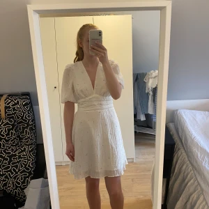 Söt Gina tricot klänning - Säljer denna söta sommarklänning från Gina tricot. Den är helt oanvänd och lappar sitter kvar. Klänningen är i storlek 38 men är liten i storlek så den är mer som en 36/S. Klänningen är vit med ett fint blommigt mönster. Köparen står för frakt💕