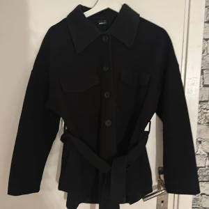 Kappa - Säljer denna kappa som är köpt från Gina tricot, köpt för ungefär 2 år sedan men knappt använd. Den är i fint skick och är i storlek xs, den har knappar hela vägen upp och snöre runt om midjan. Hör av er om ni undrar något🌸