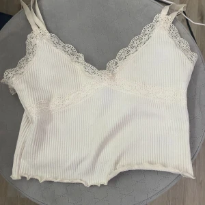 Vit topp med lite spets  - Säljs pga att det inte används längre