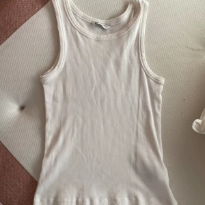 Basic tank topp vit - Säljer denna basic tank topp i vit🤍 som är perfekt att ha nu inför sommaren🥰