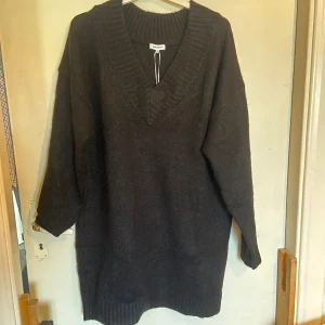 Stickad klänning - Kort stickad klänning. Köpt på Bubbleroom. Aldrig använd. V ringning fram. Jag är ca 170cm och den går till mitten av låren på mig. 