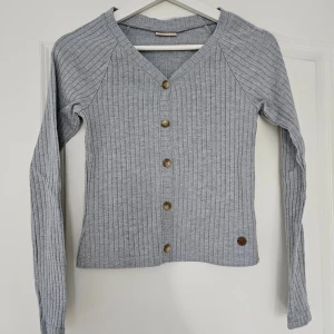 Grå ribbad topp - Fin, enkel grå ribbad topp med fastsydda knappar som detalj. Finns även en likadan i svart i min profil! 🥰