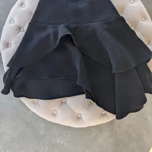 Svart asymmetrisk kjol i S från H&M. Fint skick. Tyget har en lyxig struktur. Med dragkedja 