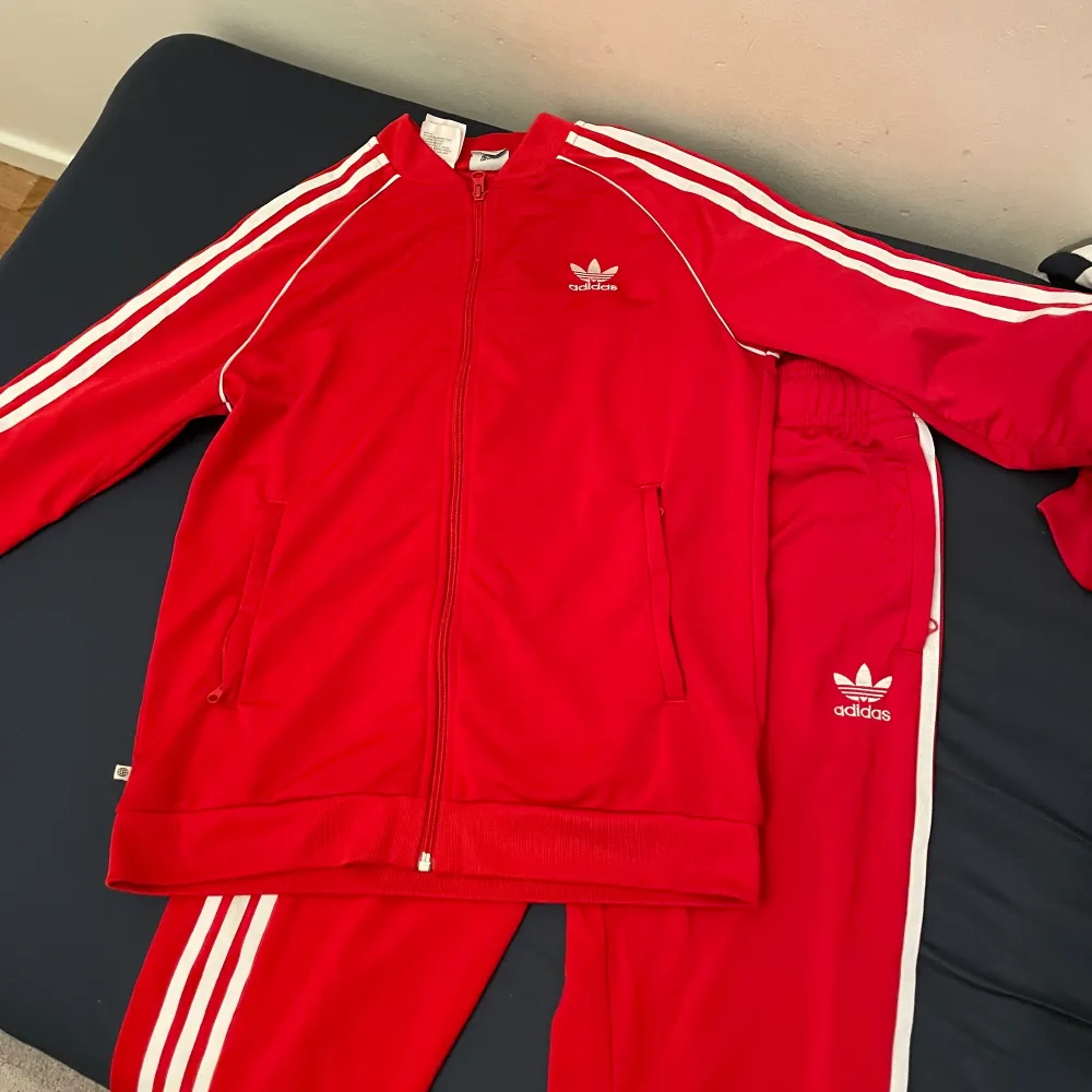 Jag säljer en fin röd adidas tracksuit. Jag har använt den Max 2 gånger men blivit liten på mig nu, därför jag säljer den. Det är storlek S eller 164-170 cm. Den sitter rätt på kroppen och är väldigt skön. Säljer den för 500 men pris kan diskuteras!. Hoodies.