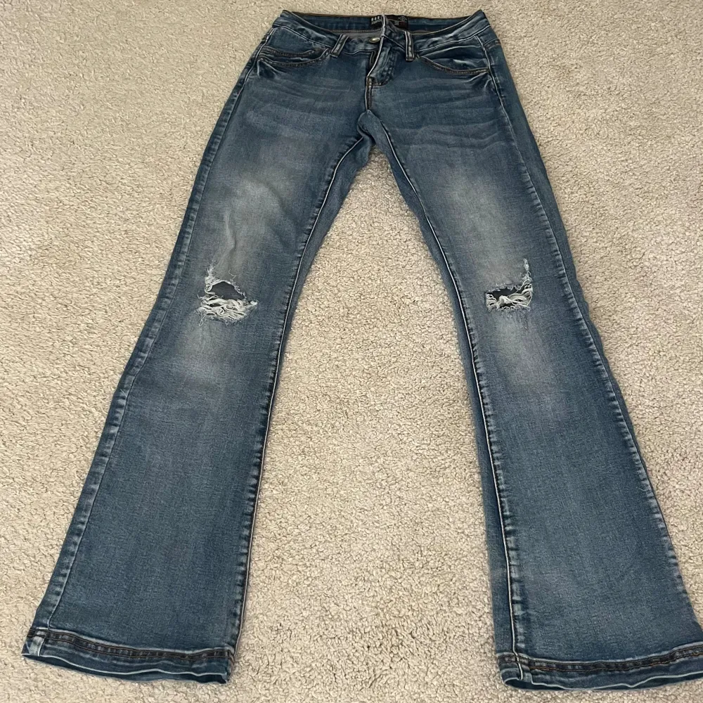 Utsvängda jeans med hål på knäna!. Jeans & Byxor.
