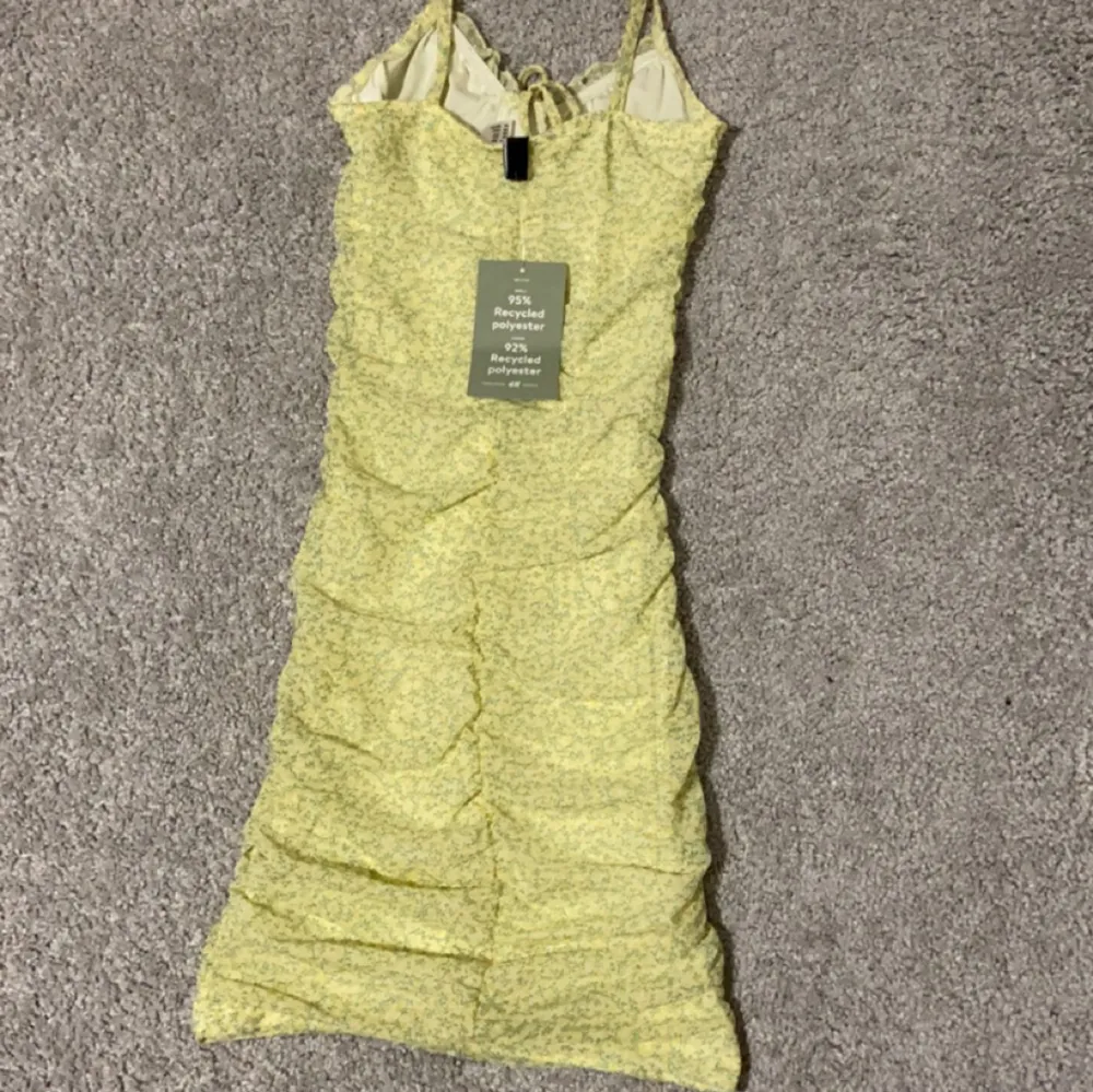 Säljer denna helt oanvända klänningen, köpte den i somras men den har inte kommit till användning. Tredje bilden visar hur den sitter på (samma modell men annan färg)❤️. Klänningar.