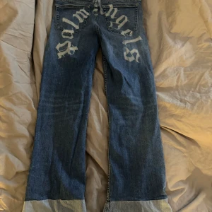 Målade Palmangels jeans xs/s - Målade utsväng jeans med palmangels text bak till. Storlek 26 passar xs-s beroende hur man vill att de ska sitta. Färgen klarar tvätt. 