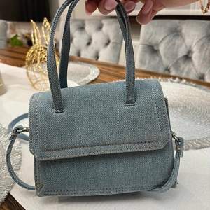 Super snygg denim väska från zara. ”Zara Denim Mini City Bag”. Den är i super nytt skick och inga defekter eller märken! Går ej att köpa hos zara längre!🩵🩵 köptes för 499kr