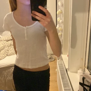 Ribbad tröja med knappar - En vit ribbad tröja med knappar från Brandy Melville. Använd ca 5 gånger och har inga defekter. Originalpris: 250 kr