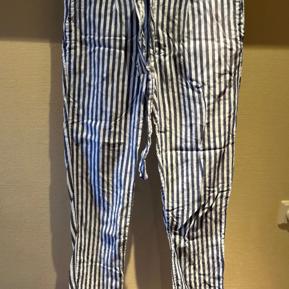 Blå/vita Tommy Hilfiger-byxor i nyskick. Väldigt sköna :). Jeans & Byxor.