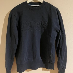 Boss tröja marinblå  - Säljer min boss tröja i färgen marinblå. Storleken är S men passar också XS. Tröjan är i bra skick och säljs pga storleken som blivit för liten. Tröjan är trendig och passar med de flesta färgade kläder. Vid fler frågor, skriv! 