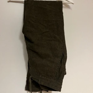 Grön tygbyxa - Lindberg  - Ett par linnebyxor i grönt från märket Lindberg. Storlek L, tapered (smalnar av vid ankeln) fit. 