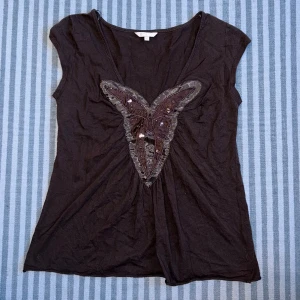 Topp - Söt topp i brunt med fjäril. Broderade paljetter och pärlor. Fint skick! 