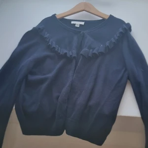 Blå kofta - Säljer denna mörkblå kofta med knappar och volanger, aldrig andvänd, är i bra skick, ( tror inte att denhär säljs mer)❤️