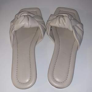 Super söta sandaler/tofflor från stradivarius. Dom är créme vita/beiga och är i storlek 39. I mycket fint skick inget trasigt eller hål🫶🏻