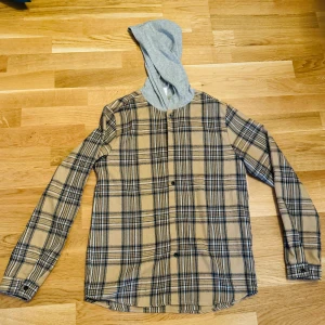 Rutig skjorta med luva - Rutig skjorta med luva väldigt bra skick använd 1 gång. Köpt för 400 kr säljer för 250 kr. För mer information och bilder kontakta mig. 