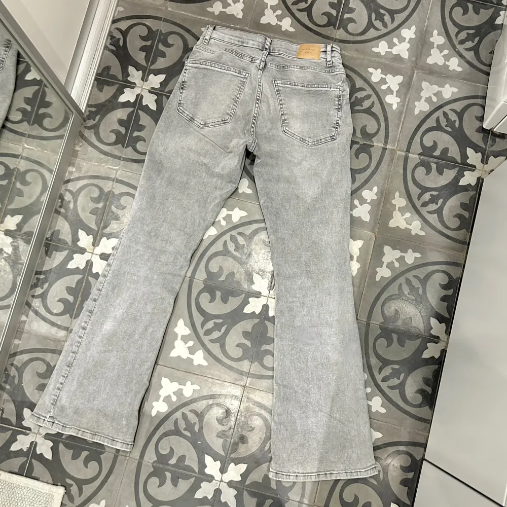 Ljusgrå, lågmidjade och utsvängda jeans från Gina Tricot i storlek 36 petite. (Passar personer 160 och kortare)  Jättefina, jättesköna och sitter bra då de har lite stretch. Endast använda ett fåtal gånger. Nypris 500kr, säljer för 350kr + frakt (:. Jeans & Byxor.