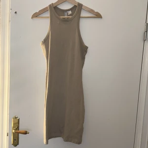 Thigt klänning  - Klänningen är i nytt skick. Finns en vit fläck som man kan se i bild, går säkerligen bort. 