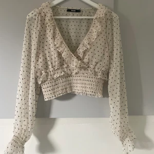 Blus  - Mönstrad volang blus med åtsittande midja 