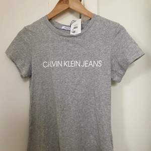 Säljer denna oanvända Calvin Klein T-shirt med lappen kvar. Nypris är 400 kr men den har dock en pytteliten fläck (se bild 2). Annars är den i nyskick. 
