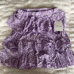 Volangkjol - Oanvänd i storlek S. Lila med vita prickar. 