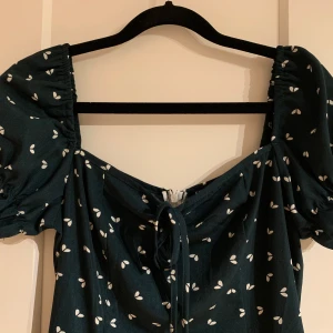 Superfin sommarklänning  - Säljer denna fina sommarklänning från Shein. Den är mörkgrön med vita ”blad”. Klänningen är lite längre, går precis över knäna för mig som är 166cm. Den är i fint skick då den endast är använd en gång. Hör av dig vid frågor💕