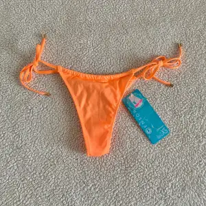 Glittrig aprikosfärgad/ orange bikiniunderdel från New Yorker. Storlek XS. Ny med tags kvar.
