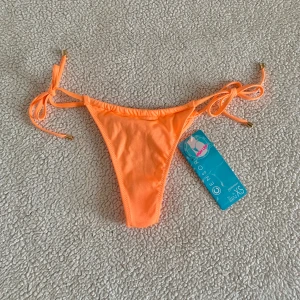 New Yorker orange / aprikos glittrig bikiniunderdel  - Glittrig aprikosfärgad/ orange bikiniunderdel från New Yorker. Storlek XS. Ny med tags kvar.