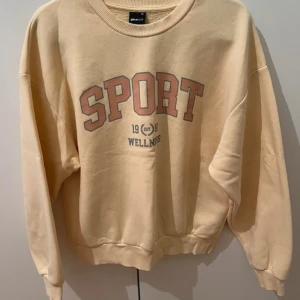 Collegetröja  - Ljus gul collegetröja i använt skick men fortfarande i ett bra skick. 