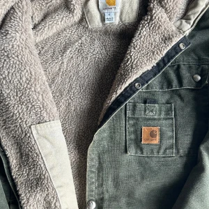 Carhartt workwear jacket   - En ovanlig olivgrön carharrt jacka i riktigt bra skick. Har aldrig sett denna här varianten tidigare men fodrad insida och luva. Den är storlek L, Mått; Bredd (63), Längd (65), armar(66).