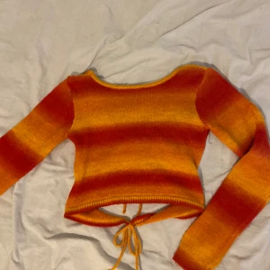 Y2K urban outfitters - Orange/röd tröja med knytning från urban outfitters. Man kan ha den på båda hållen. Stickad, bra kvalité. Endast använd 1 gång.