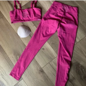 Gymshark set legacy bandeau träningstights rosa pink - Jättefint set med byxor och bh f gymshark i superfint skick. Uttagbara inlägg till träningsbhn.   