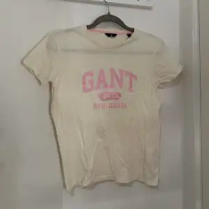 Beige/vit Gant T-shirt med rosa tryck, råkar ha två lika dana så dena har bara legat i garderoben inte använd🩷 Storlek 170 men passar mig med storlek S