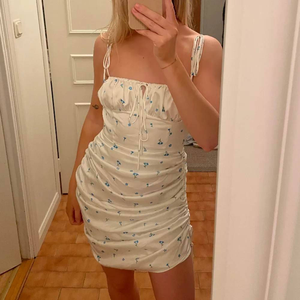 Säljer min vit/blå blommiga ”Santorini dress” från adoore. Helt slutsåld🩵🩵. Klänningar.