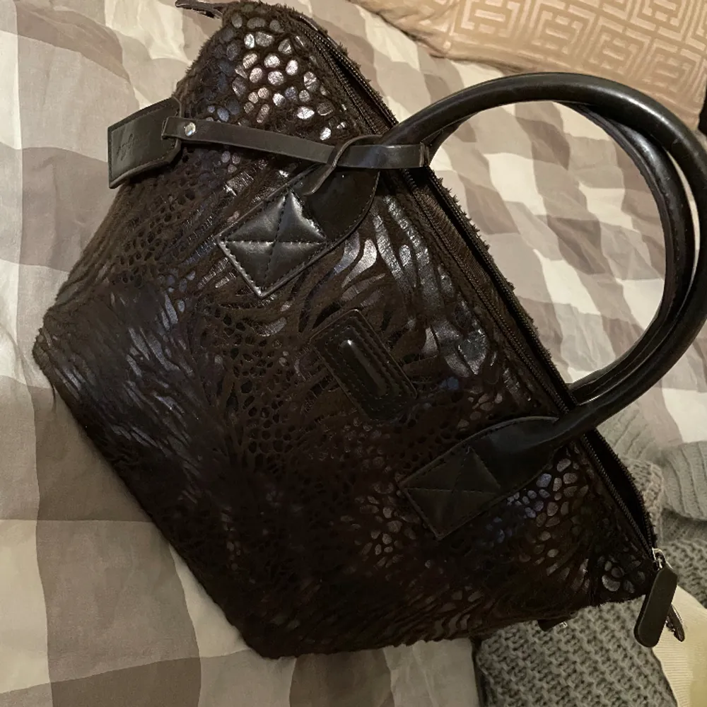 Snygg mörk brun väska med mönster, används inte. Skriv för mer frågor😊. Väskor.