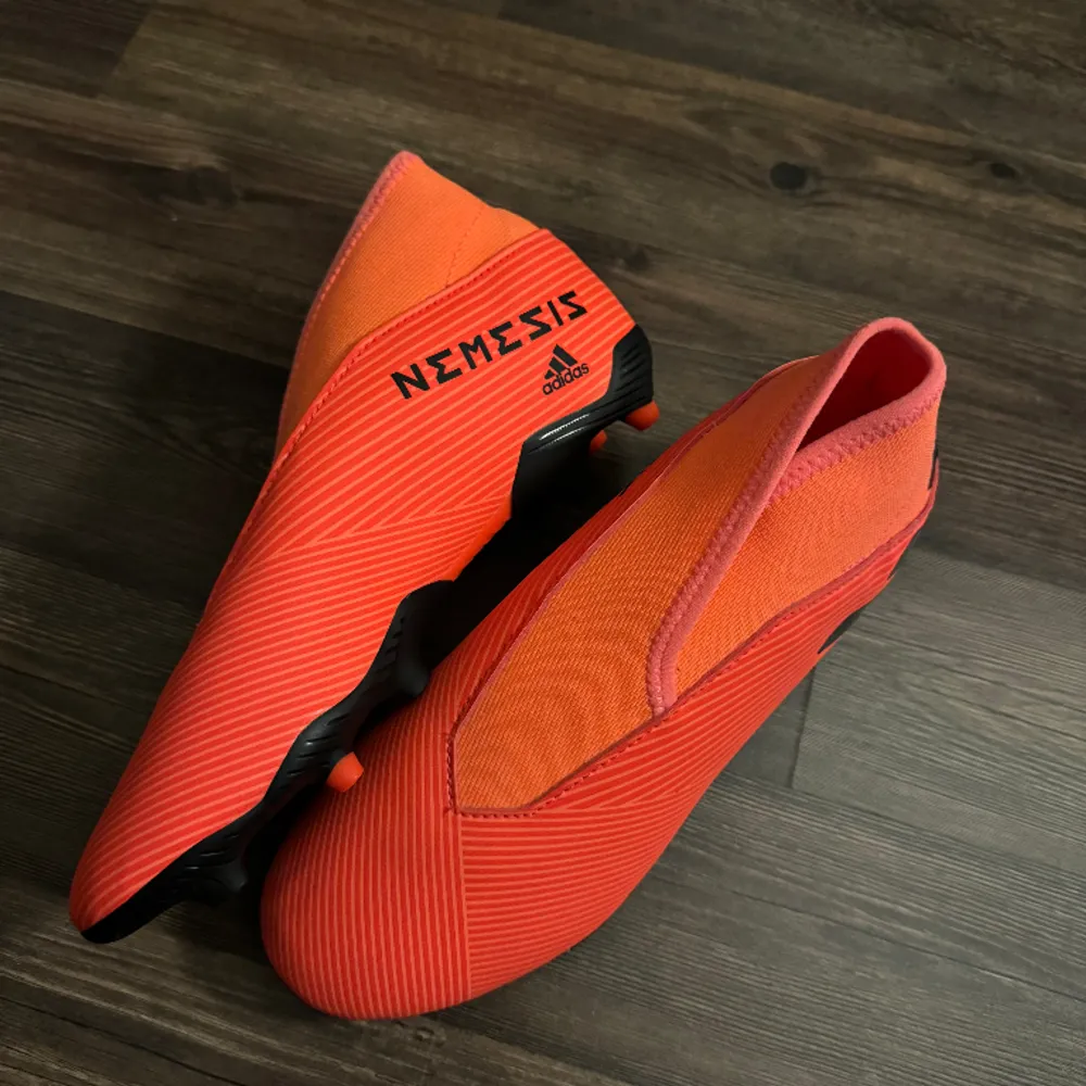 Orangea/röda fotbollsskor från Adidas i storlek 36 och två tredjedelar. Helt oanvända och i mycket bra skick!. Skor.
