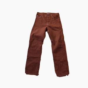 Ett par oanvända Junkyard jeans i mörk-orange-brun ish färg. Passform är straight, storlek 30.   Skriv för mer info elr bilder.  Kan även arrangera byte mot annat plagg.