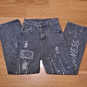 Gråa jeans med tryck - Jeans med coola tryck! De är väldigt höga i midjan, knappt använda och inte sönder någonstans :) säljer för att det inte är min stil längre pris kan diskuteras💗