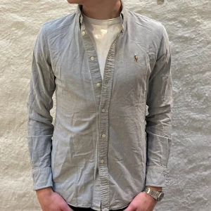 Ralph Lauren skjorta  - Ralph lauren skjorta i färgen grå. Storlek S och modellen är 178 cm. Nyskick, inga skavanker. Nypris 1699kr kr, köp för endast 549kr.