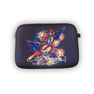 Ed hardy datorväska/fodral - En äkta Ed hardy väska/fodral  som är rymlig med cool design 35 cm bred 23 cm hög ! Den har en liten fläck på baksidan bild 3, men det går lätt att bort om man tvättar bort de.  Hör av dig om du är intresserad 🌱