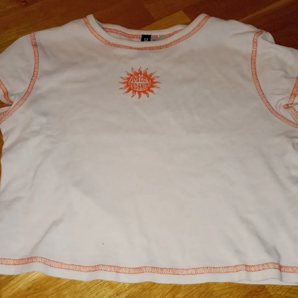 Gräddvit croptop med orangea detaljer. Nyskick. Köpt på hm i storlek xs. . Toppar.