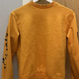 Orange tröja med rosor på armarna - bra skick 🫶