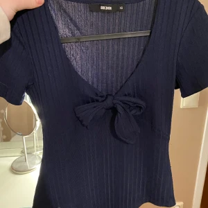 Mörkblå Body - Mörkblå body från Bik Bok. Storlek XS men känns mer som en S. Knytbar rosett i bröstet. Använd få gånger, jättebra skick! 