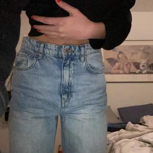 Ett par blåa jeans med slits