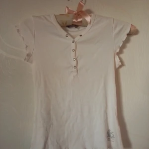Fin kortärmad topp - Vit kortärmad topp med diamant knappar. Storleken 146. Är i fint skick.