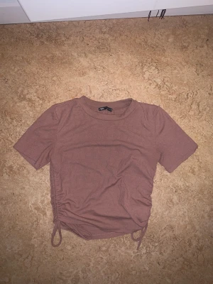 Tröja/T-shirt - Fin nouvefärg med justerbara snören längs sidan för fin detalj och egen stil.