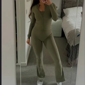 Mörkgrön jumpsuit plt - Ett snyggt set från PLT Leggins o Zip tröja i en mörkgrön färg. Jackan har en dragkedja framtill och är perfekt för både vardag och gym. Den är bekväm att bära och passar bra till allt. (Identisk med den från Lululemon) Allt är i storlek S (stretchig