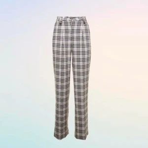 Rutig byxa från NA-KD - Säljer ett par snygga rutiga byxor från NA-KD. De är högmidjade och har en straight fit. Byxorna är i en beige och svart färgkombination och är tillverkade av 97% polyester och 3% elastan, vilket gör dem både bekväma och stretchiga. Perfekta för både vardag och fest!